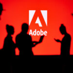 Indrukwekkende silhouetten van mensen die voor het Adobe-logo staan en hun expertise op het gebied van Adobe Creative Suite voor website-ontwerp demonstreren.